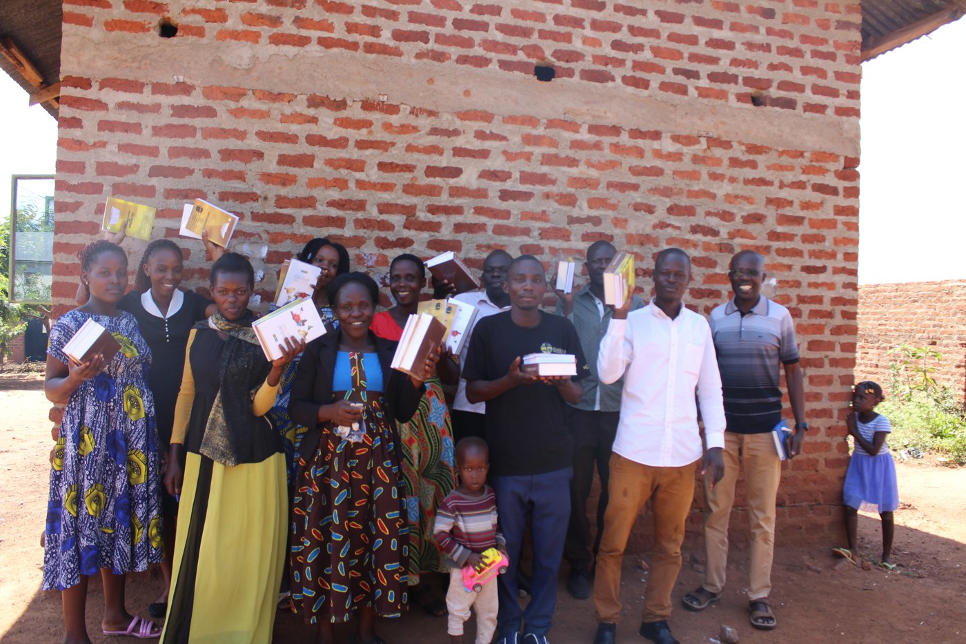 A congregation holding up newly received study materials