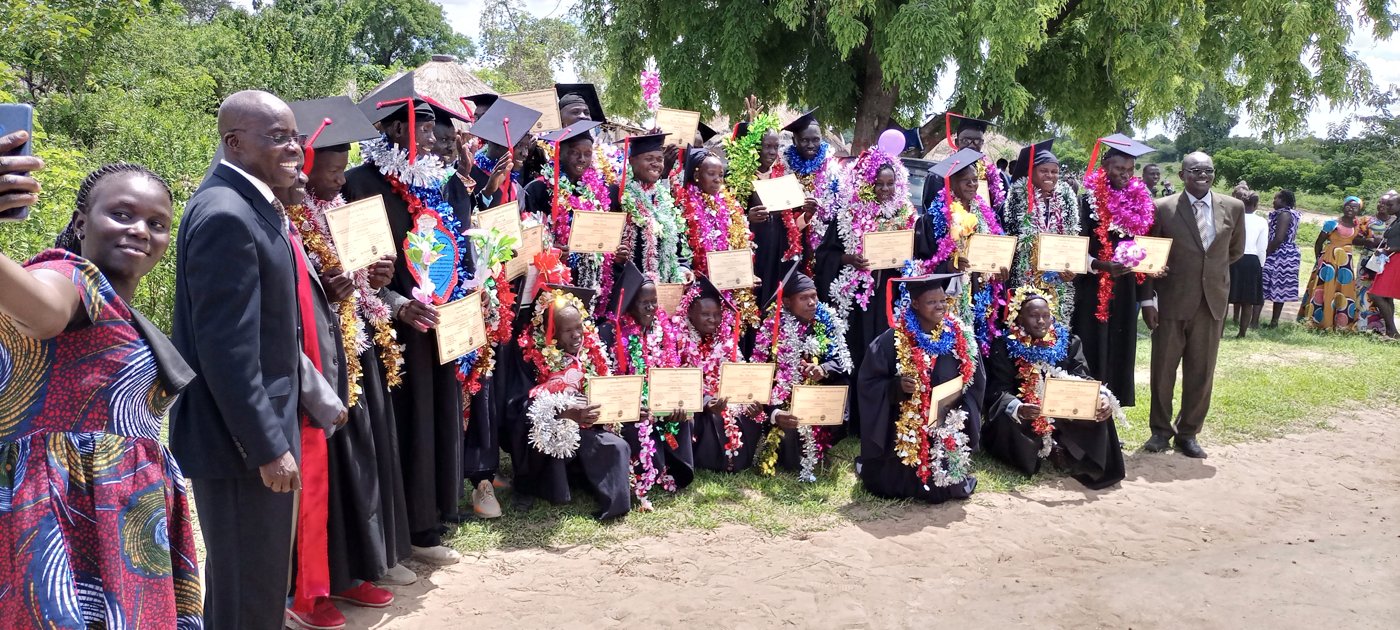 Rural graduation ceremony under a large tree
