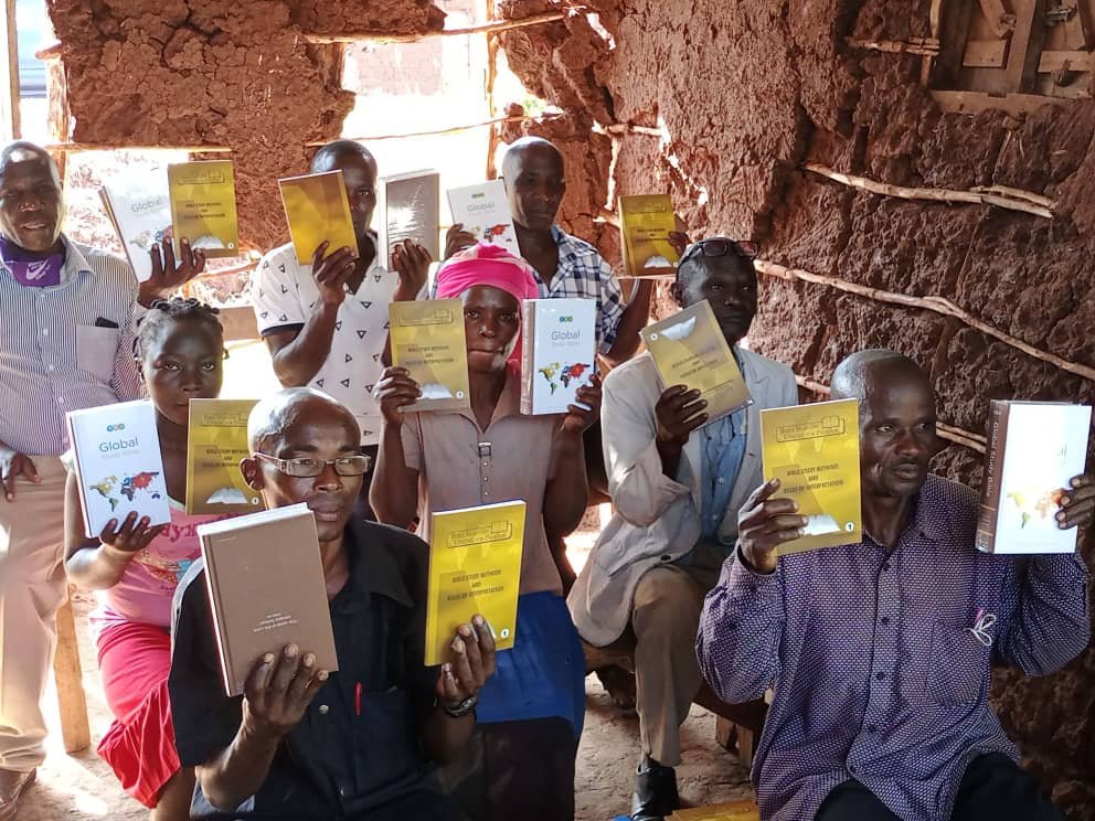 A community leader holding trauma healing training materials